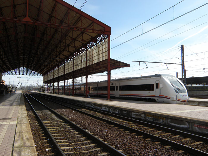 Vista de la marquesina desde los andenes, con el tren de Media Distandia esperando salir para Vigo