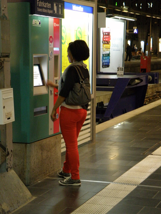 Viajera comprando su billete en una m�quina autoventa en la cabecera de and�n