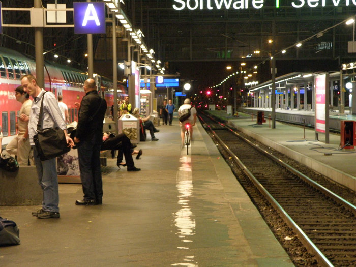 Un ciclista pedalea por el and�n hacia su tren