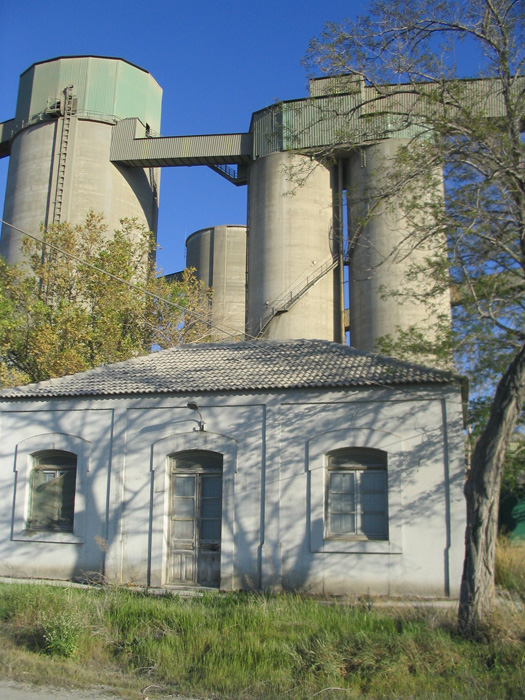 Fachada, lado calle, del edificio de viajeros de Villaluenga-Asland. Al fondo los silos de la cementera