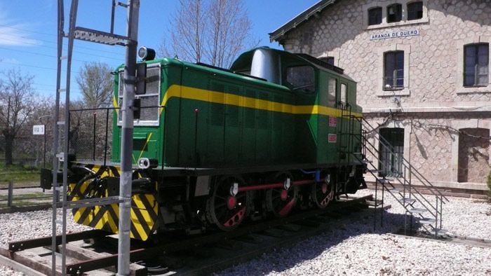Perspectiva de un tractor de maniobras de las serie 10000 junto al edificio de viajeros.